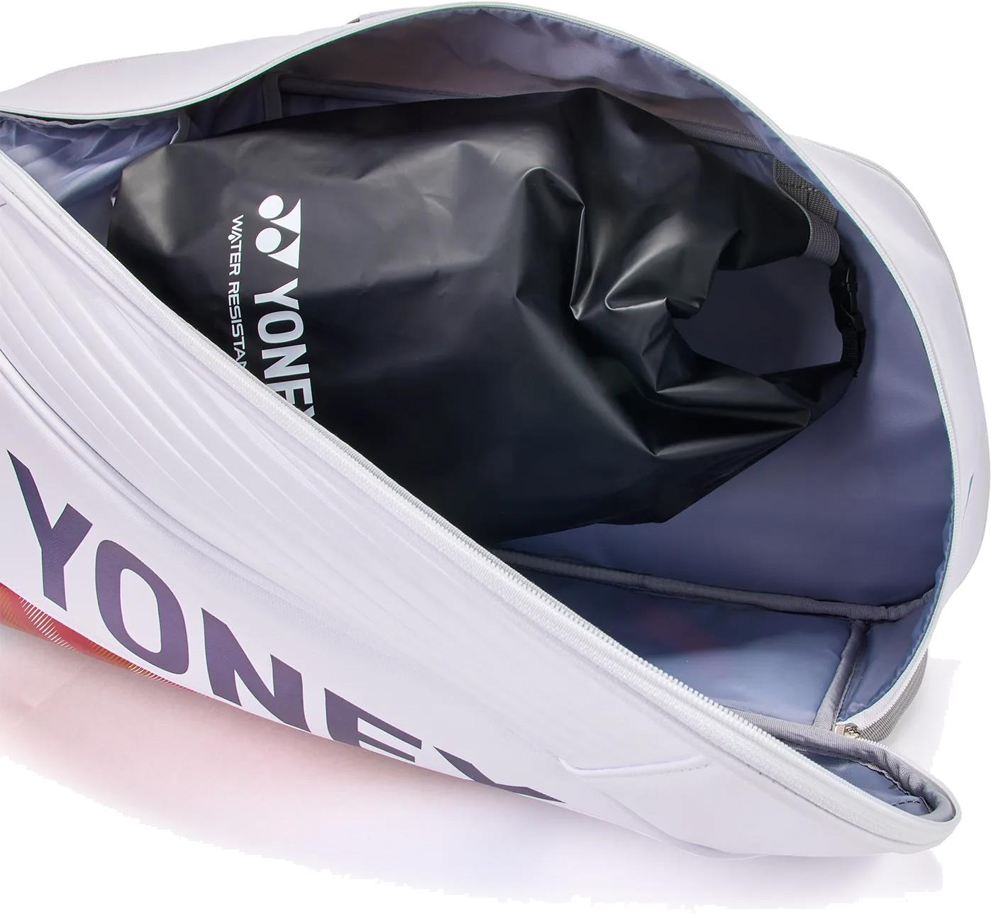 The Yonex 02626EX Expert 6 Racket Badminton Bag - White is unzipped to reveal a black, water-resistant Yonex pouch. Its light gray interior offers compartments and Thermo Guard, keeping your gear organized and protected.