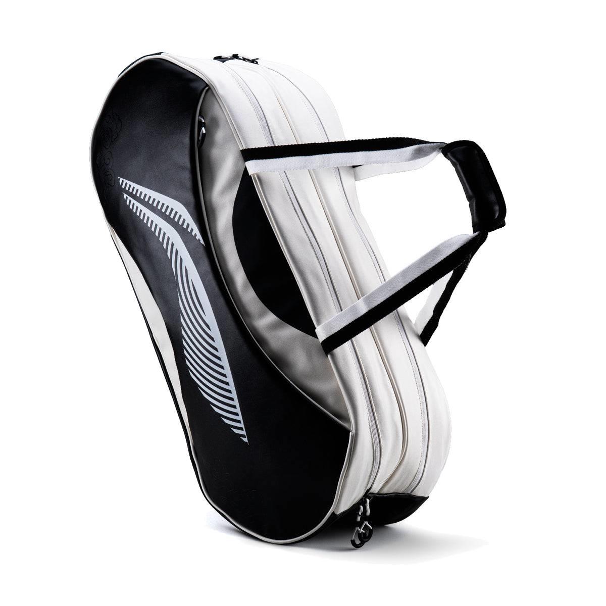 The Li-Ning Competition 6 Racket Badminton Bag in white and black features two zippered compartments, black and white handles, a large black side panel with a white leaf design, and holds up to 6 rackets.