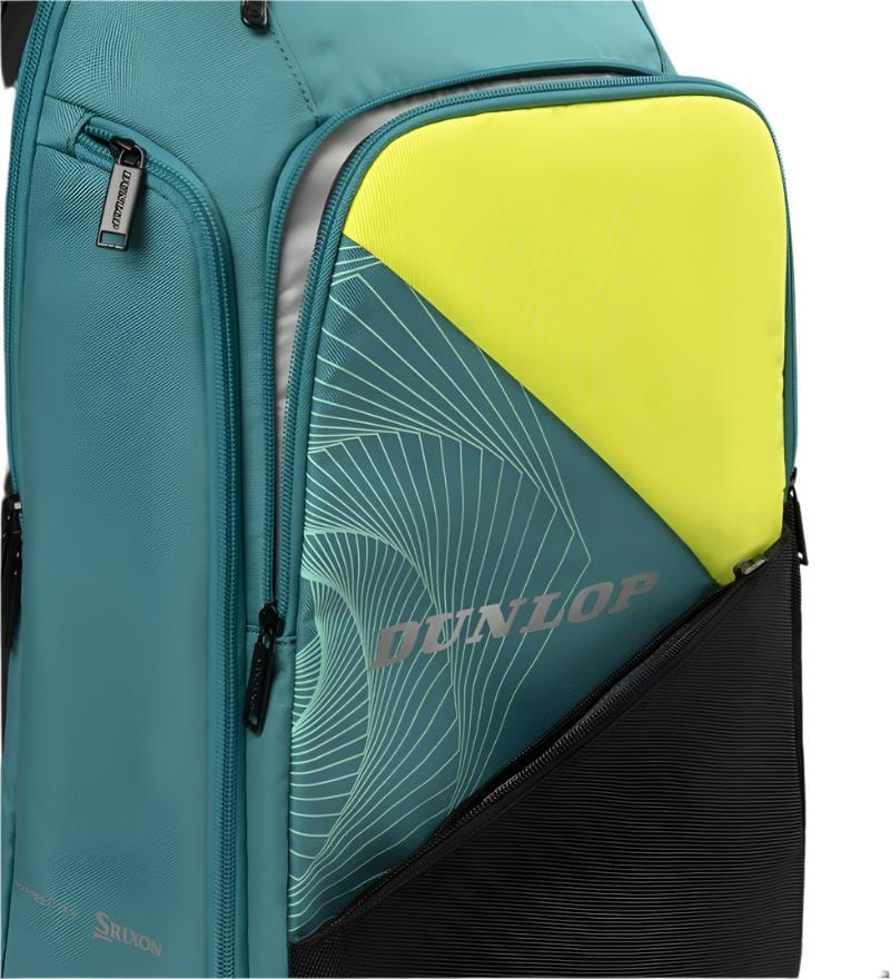 A Dunlop SX Performance Badminton Backpack in teal, black, and yellow, featuring a geometric patterned front pocket, multiple zippered compartments for storage, and ergonomic shoulder straps for comfort.