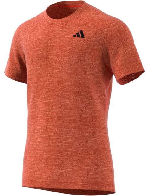 The ADIDAS Mens Freelift Badminton T-Shirt in vibrant red, from the adidas brand, is designed with a small black logo on the left chest. It features AEROREADY fabric for optimal performance and a textured short sleeve design. The item is showcased against a white background.