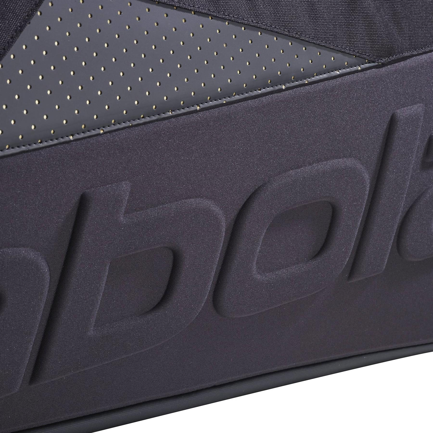 Close-up of a Babolat Cross Pro Badminton Bag - Black / Gold showing the embossed "Babolat" logo and small perforated holes above its thermoformed shell.