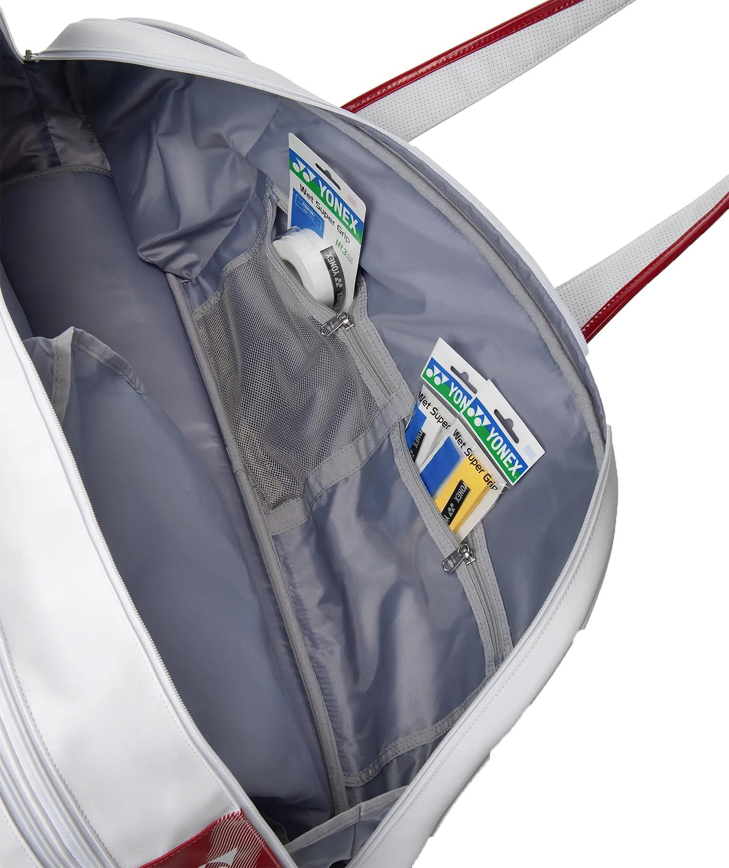 The Yonex 02631WEX Expert Tournament Badminton Bag in white features silver-grey lining, red shoulder straps, and an inner zipper mesh pocket storing two Yonex grip tapes and a roll of white grip tape—ideal for tournaments.