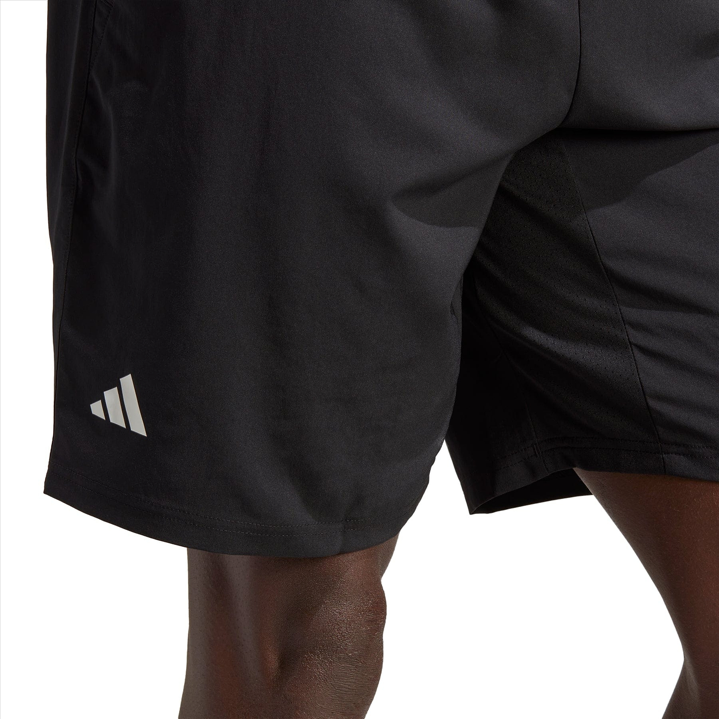 Close-up of a person wearing the black adidas Club 3 Stripe 7" Men's Badminton Shorts, featuring the iconic logo on the left leg. The image focuses on the lower body, showcasing the shorts' moisture-wicking fabric and sleek design, ideal for badminton enthusiasts.