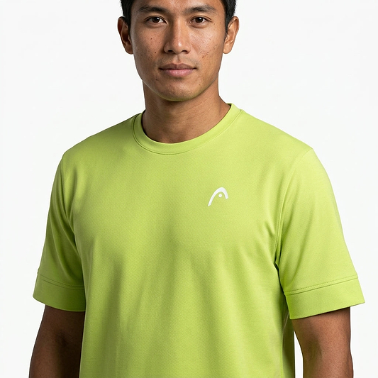 A man wearing a HEAD Slice II Men's Badminton T-Shirt by HEAD, in light green with moisture-wicking fabric and a small white chest logo, stands against a plain white background.