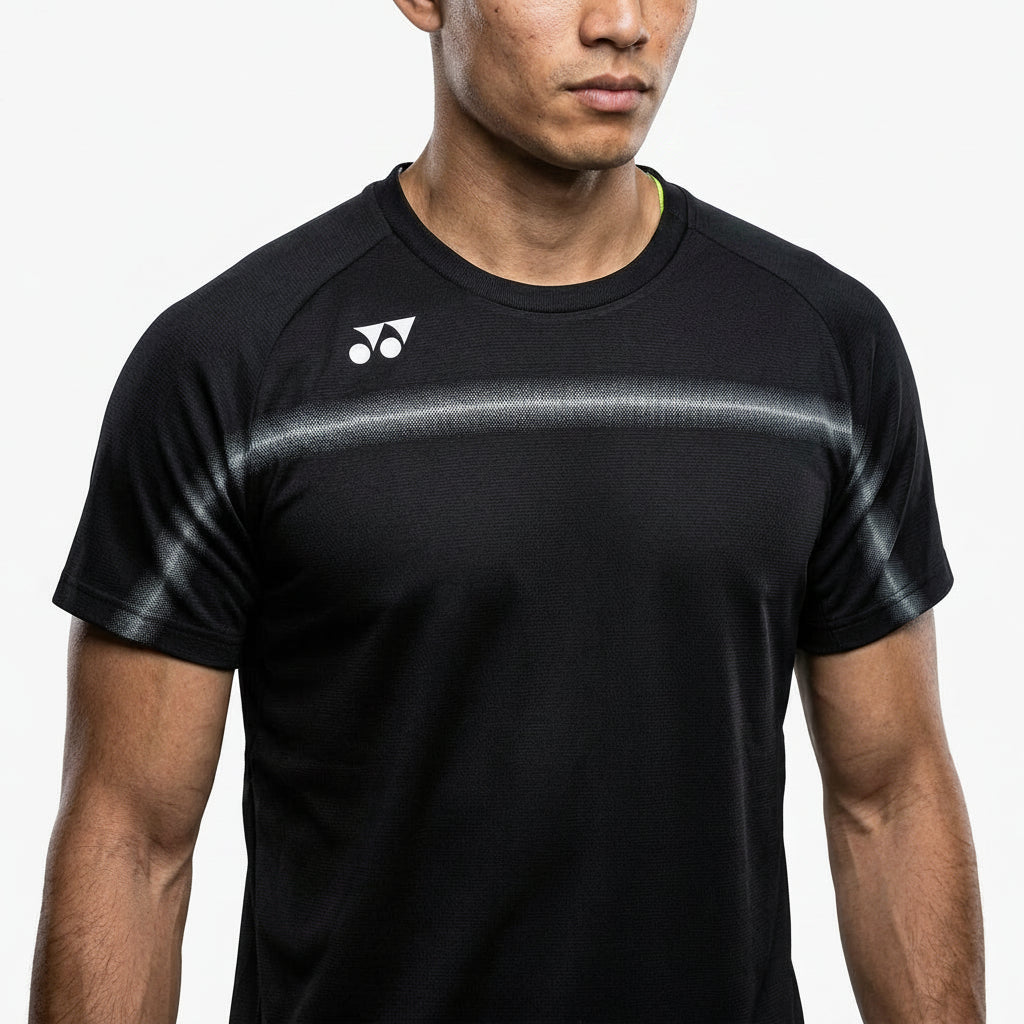 A man wears the Yonex 10711YX Crew Neck Men's Badminton T-Shirt in black, featuring a white Yonex logo on the left shoulder. Only his mouth and chin are visible as he stands against a plain white background.