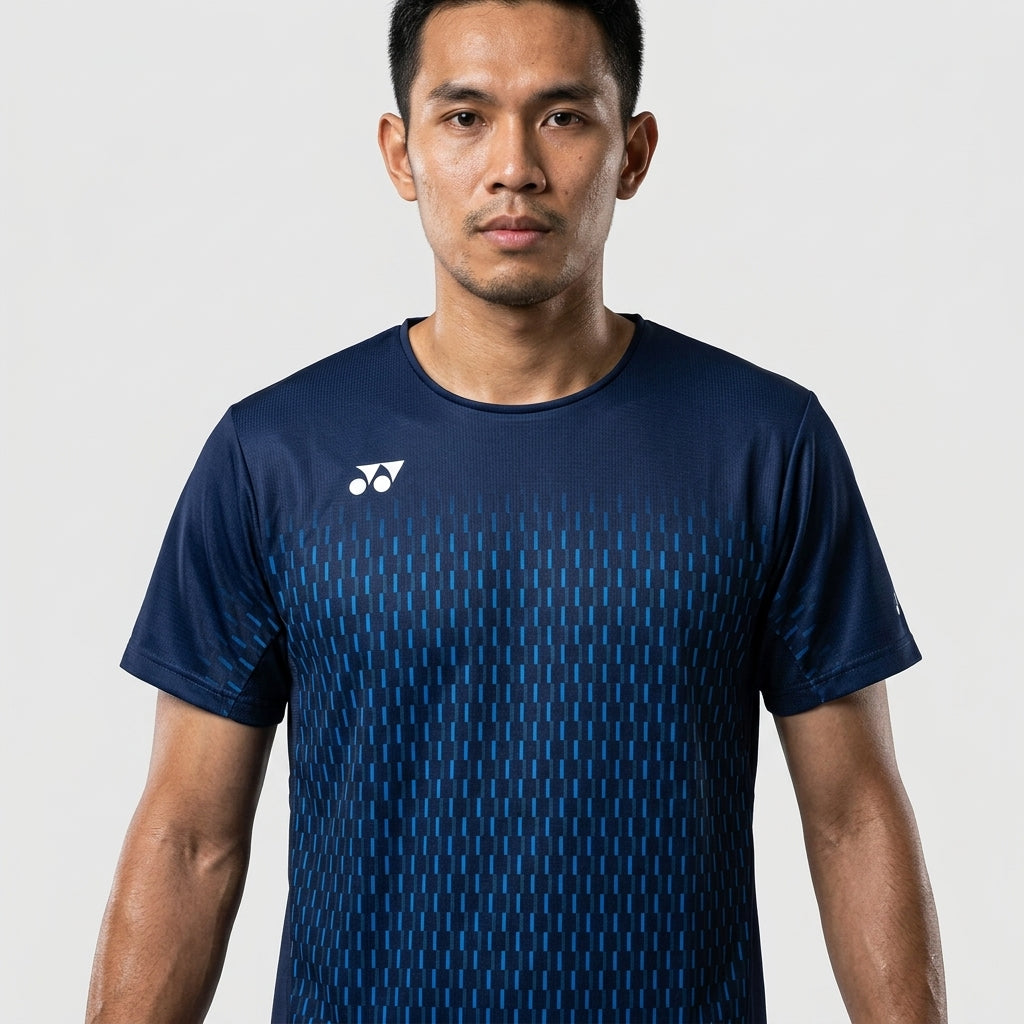 A man with short black hair stands against a plain light background, wearing the Yonex 10713EX Crew Neck Men's Badminton T-Shirt in dark navy, featuring moisture management fabric and a small white Yonex logo on the left shoulder.