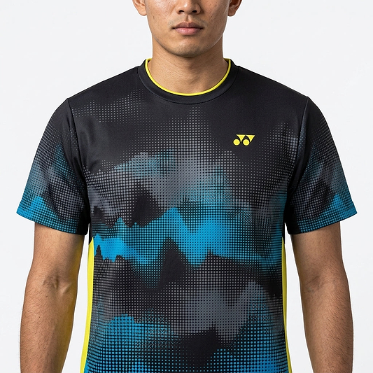 A man faces forward wearing the Yonex YTM2025A Men's Badminton T-Shirt in black, featuring an abstract black and blue design, yellow Yonex logo, quick-dry technology, and yellow trim on the collar and sides. Only his upper body is visible.