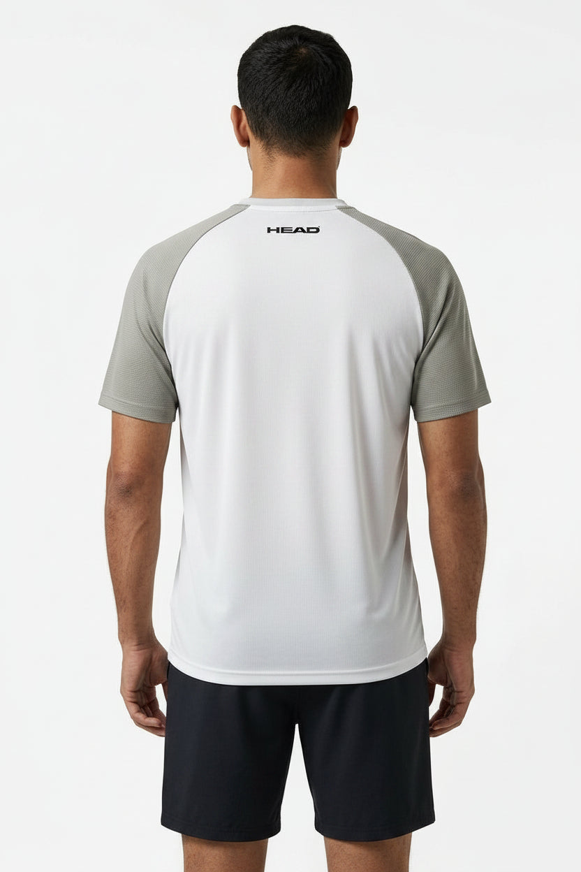 A man faces away, wearing the HEAD Performance Men's Badminton T-Shirt - XPWG in white and gray with "HEAD" on the upper back, paired with black shorts, set against a plain white background.