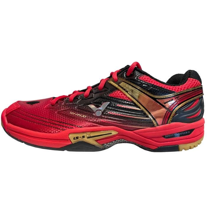 Introducing the Victor SH A920 Red Badminton Shoes by Victor, a striking red athletic shoe designed with black and gold accents. Its low-cut silhouette and textured sole make it perfect for indoor sport enthusiasts. Featuring black laces, sleek logos, and excellent lateral support, this shoe is the ideal choice for agile badminton players.