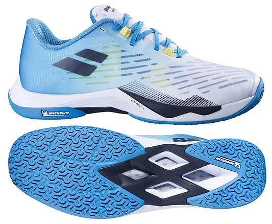 The Babolat Shadow Tour 5 Men's Badminton Shoes - Algier Blue feature light blue and white colors with blue and yellow accents, a black logo, and blue patterned soles—ideal for indoor courts. Shown from side and bottom angles.