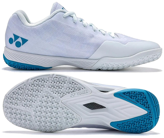 The Yonex Power Cushion Aerus Z2 Men's Badminton Shoes in White/Blue feature a mesh upper, cushioned Power Cushion sole, textured outsole, and Aerus Z2 branding on the heel, shown from the side and bottom.