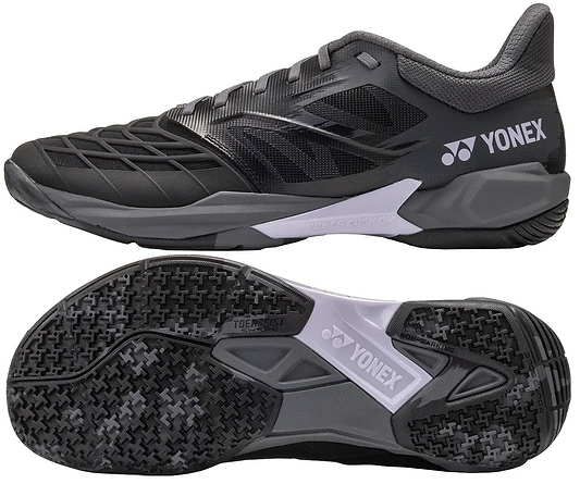 The Yonex Power Cushion Cascade Drive 3 Unisex Badminton Shoes in Black/Grey are shown from the side and bottom, with a textured upper, detailed tread, gray sole with Power Cushion tech, and Yonex branding.