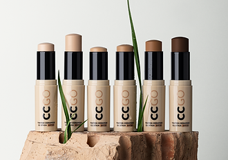 MÁDARA Tinted Ceramide CC Stick SPF30 in multiple shades, arranged in a row on a natural clay surface with green plant accents