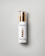 Model wearing MÁDARA Organic Skincare healthy glow self tan serum for face A3421 serum on skin; close-up portrait shows natural application results.