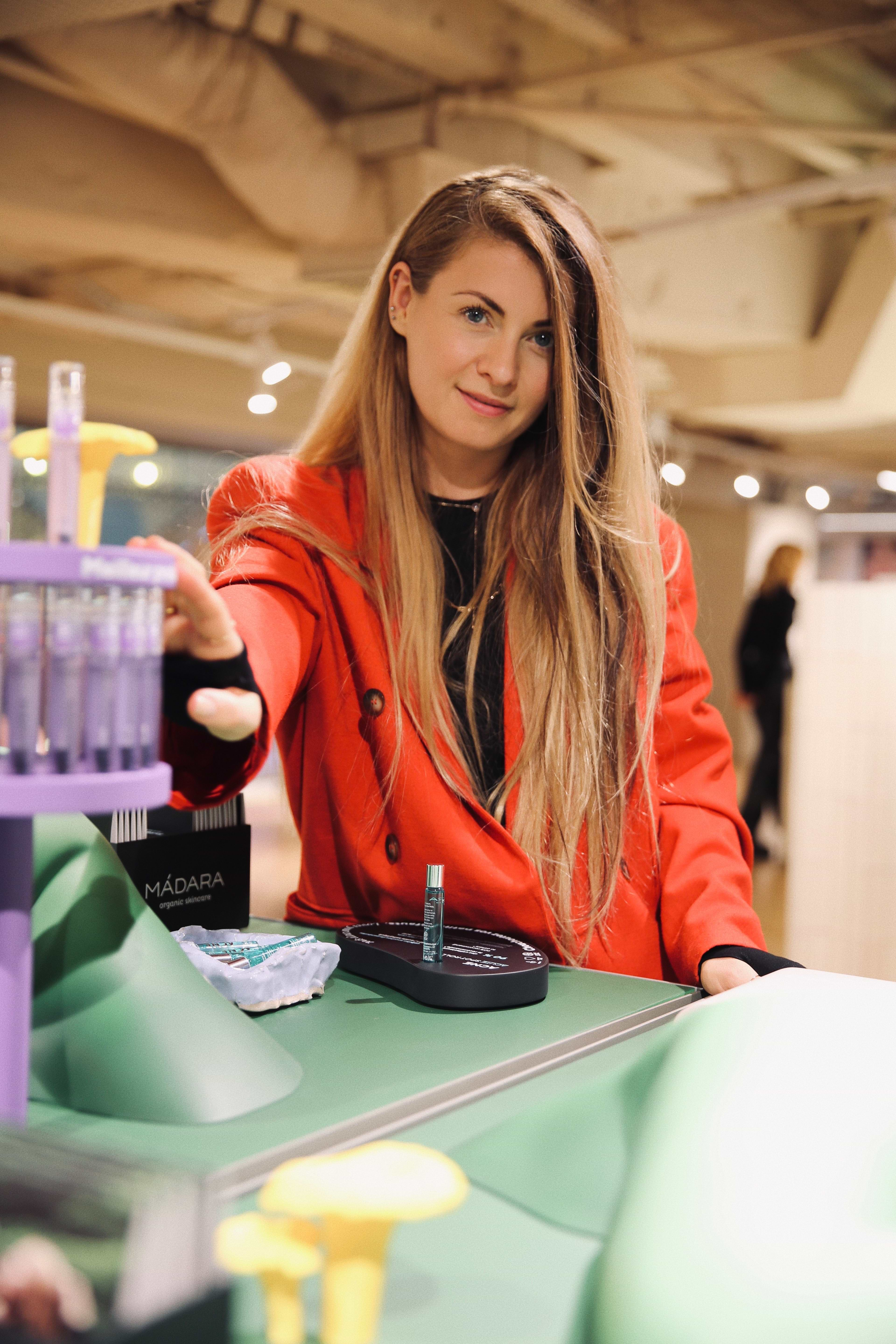 Founder of Madara Cosmetics, Lotte Tisenkopfa-Iltnere next to a display of Madara Cosmetics products