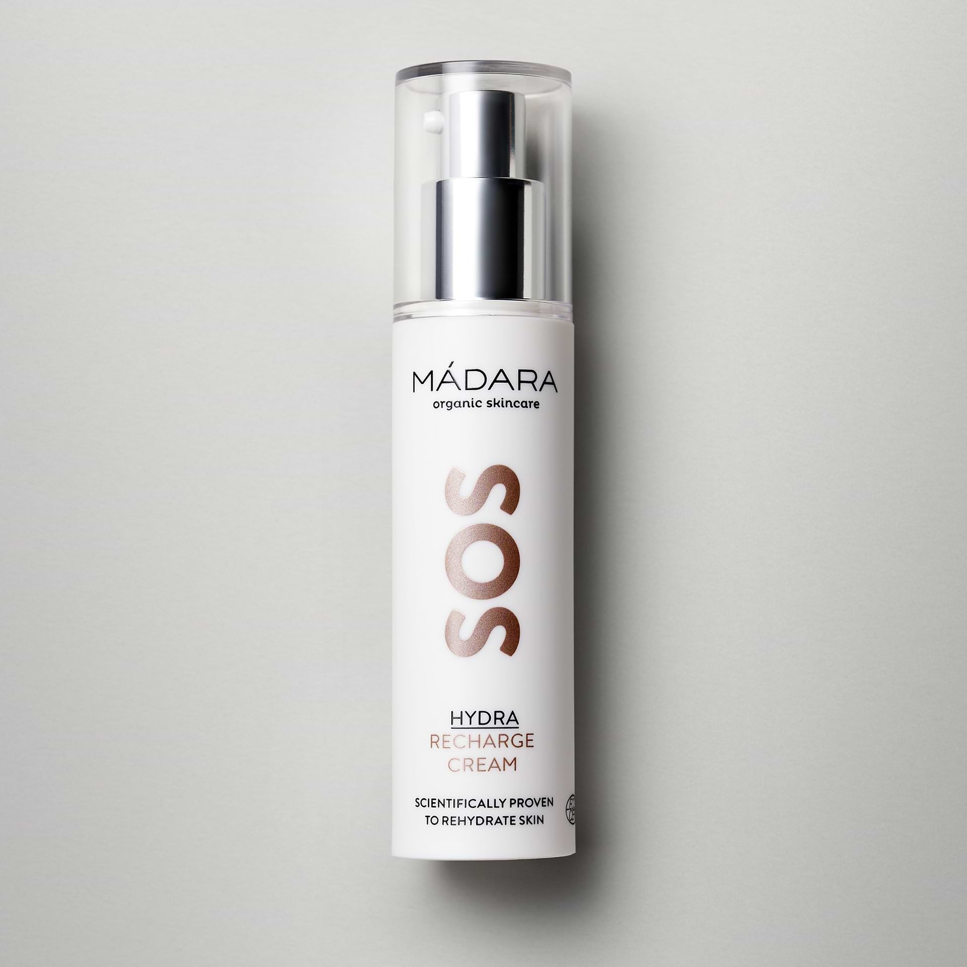 50 ml pump bottle of Madara Organic Skincare SOS Hydra Recharge Face Cream with plastic cap on a grey background