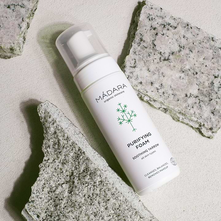 150 ml bottle of Madara Organic Skincare Purifying Foam for face cleansing next to marble-like rocks