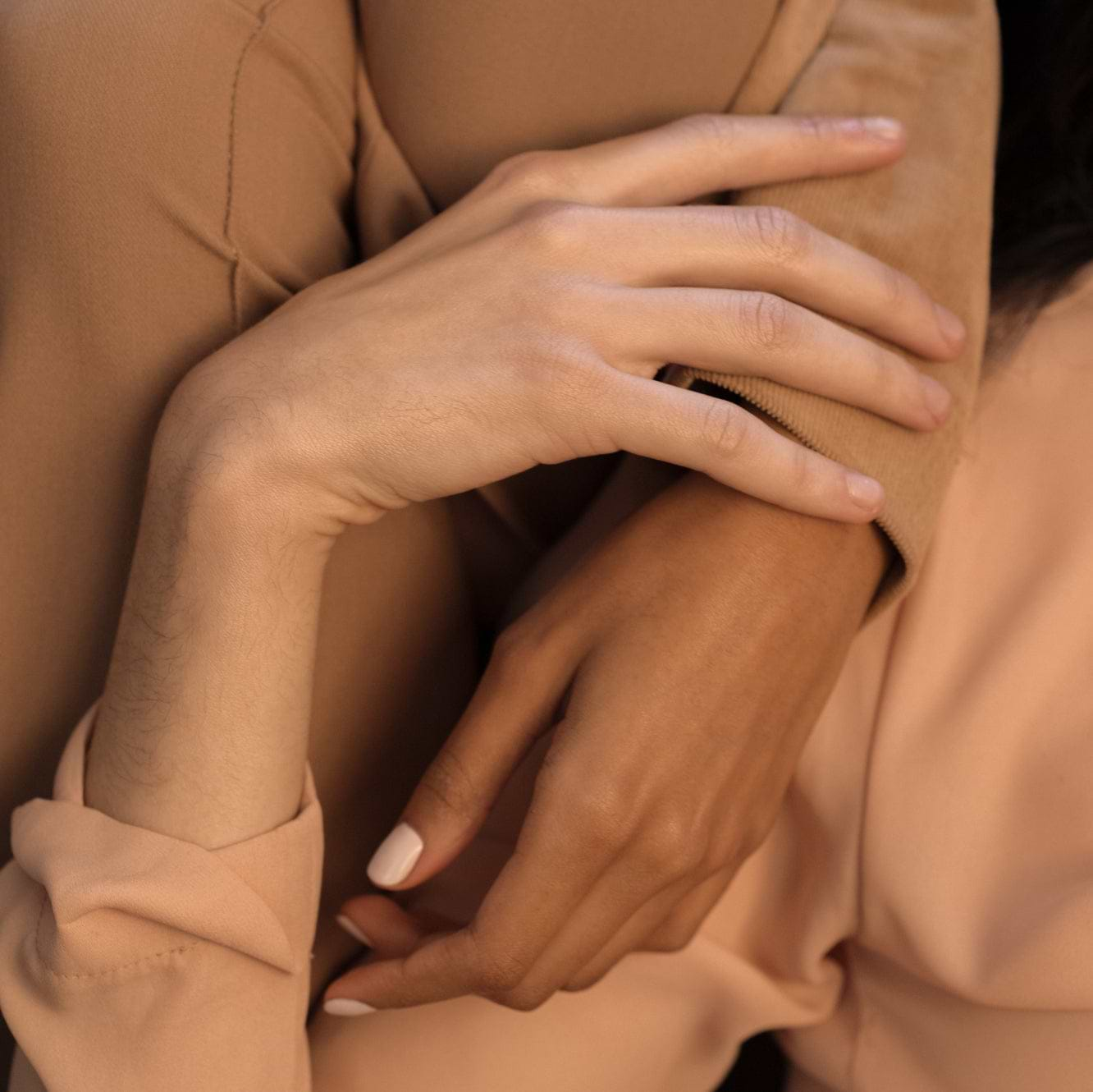 Women’s hands gently touching each other