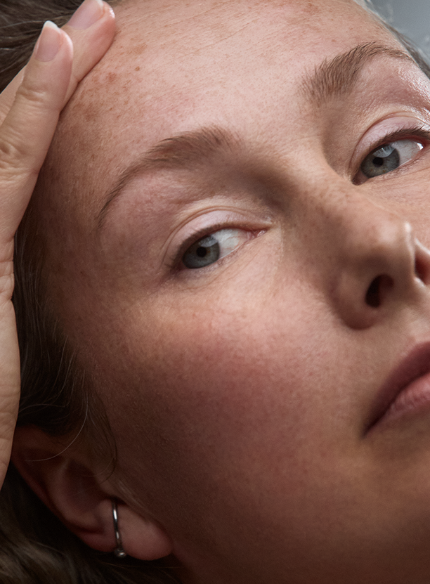 Close-up of a woman’s face showing natural skin texture and freckles