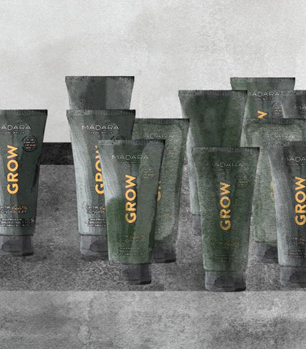 MÁDARA GROW line product tubes standing on a gray, textured surface