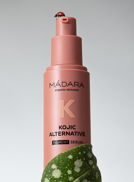 MÁDARA Kojic Alternative Pigment Serum bottle with no cap, green leaves, and a ladybug on the packaging.