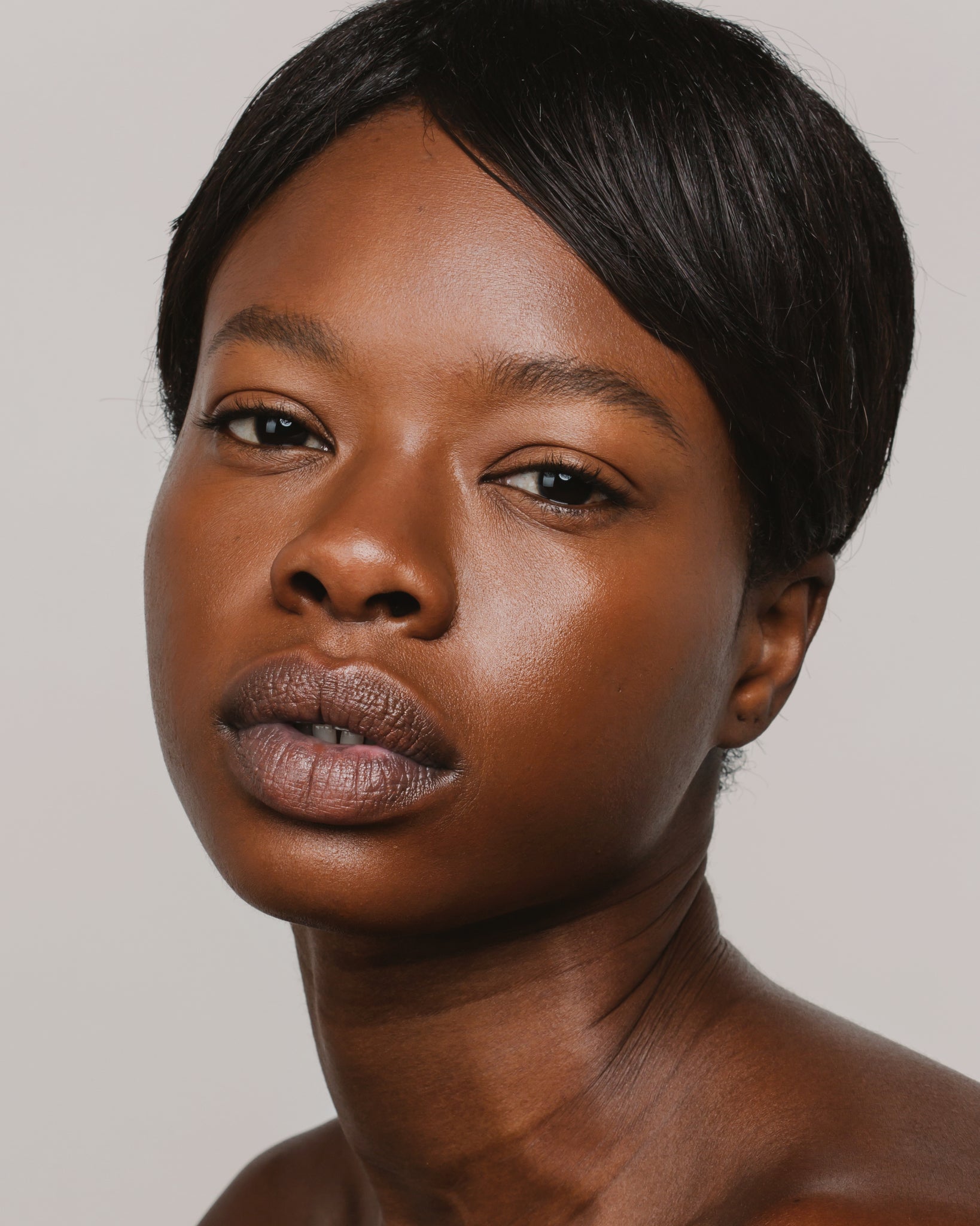 Model wearing MÁDARA Organic Skincare skin equal chestnut on A6067 on skin; close-up portrait shows natural application results.