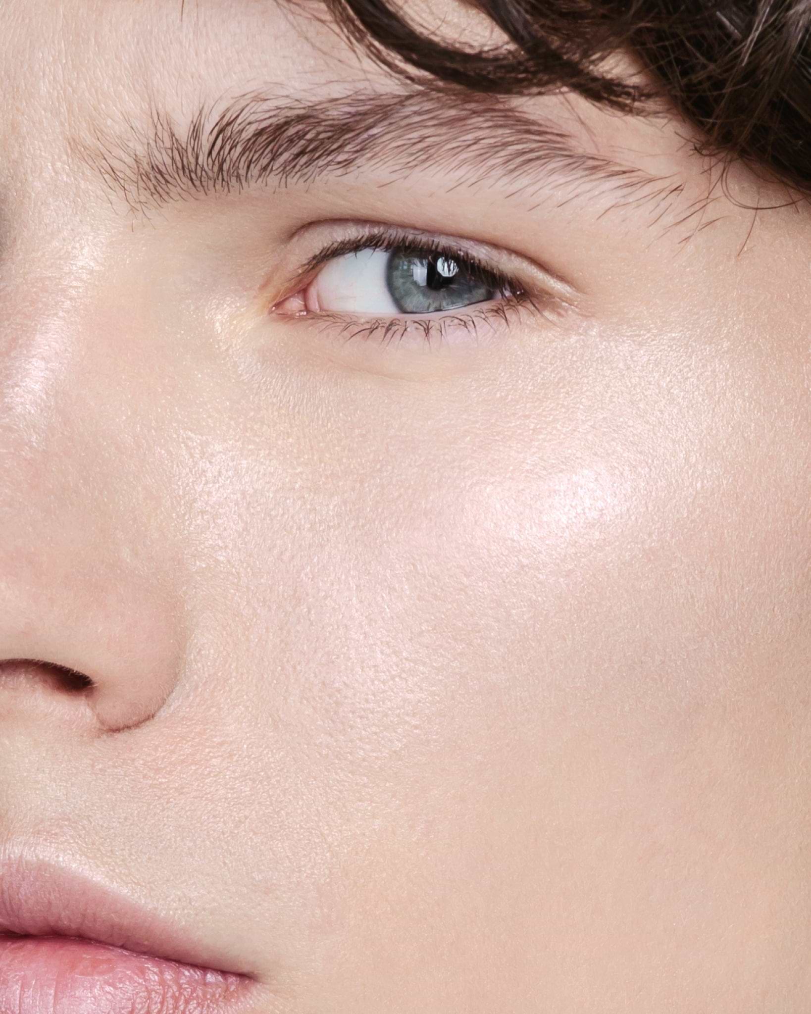Model wearing MÁDARA Organic Skincare the concealer latte on A6101 concealer on skin; close-up portrait shows natural application results.