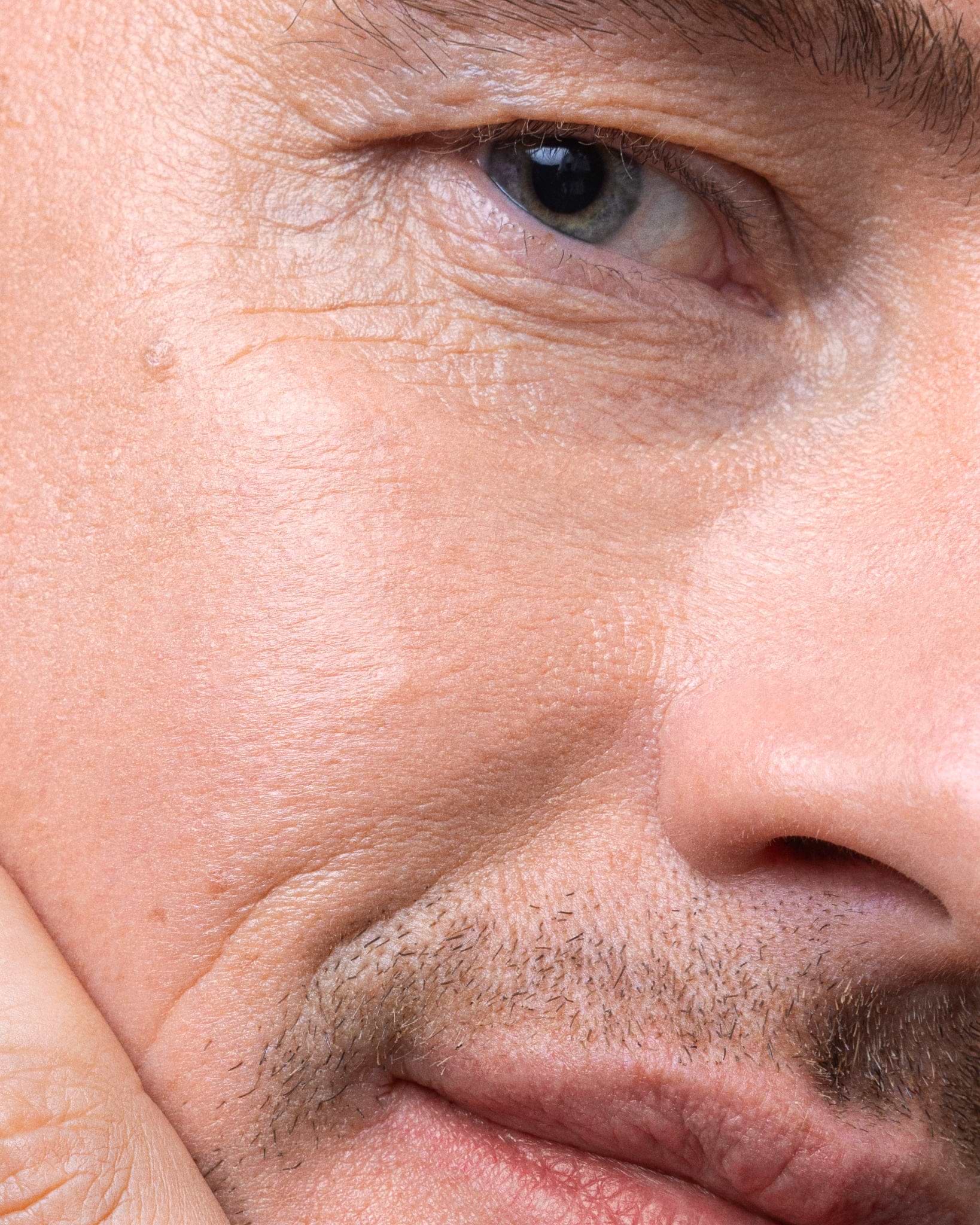 Model wearing MÁDARA Organic Skincare moon flower serum on A3512 serum on skin; close-up portrait shows natural application results.