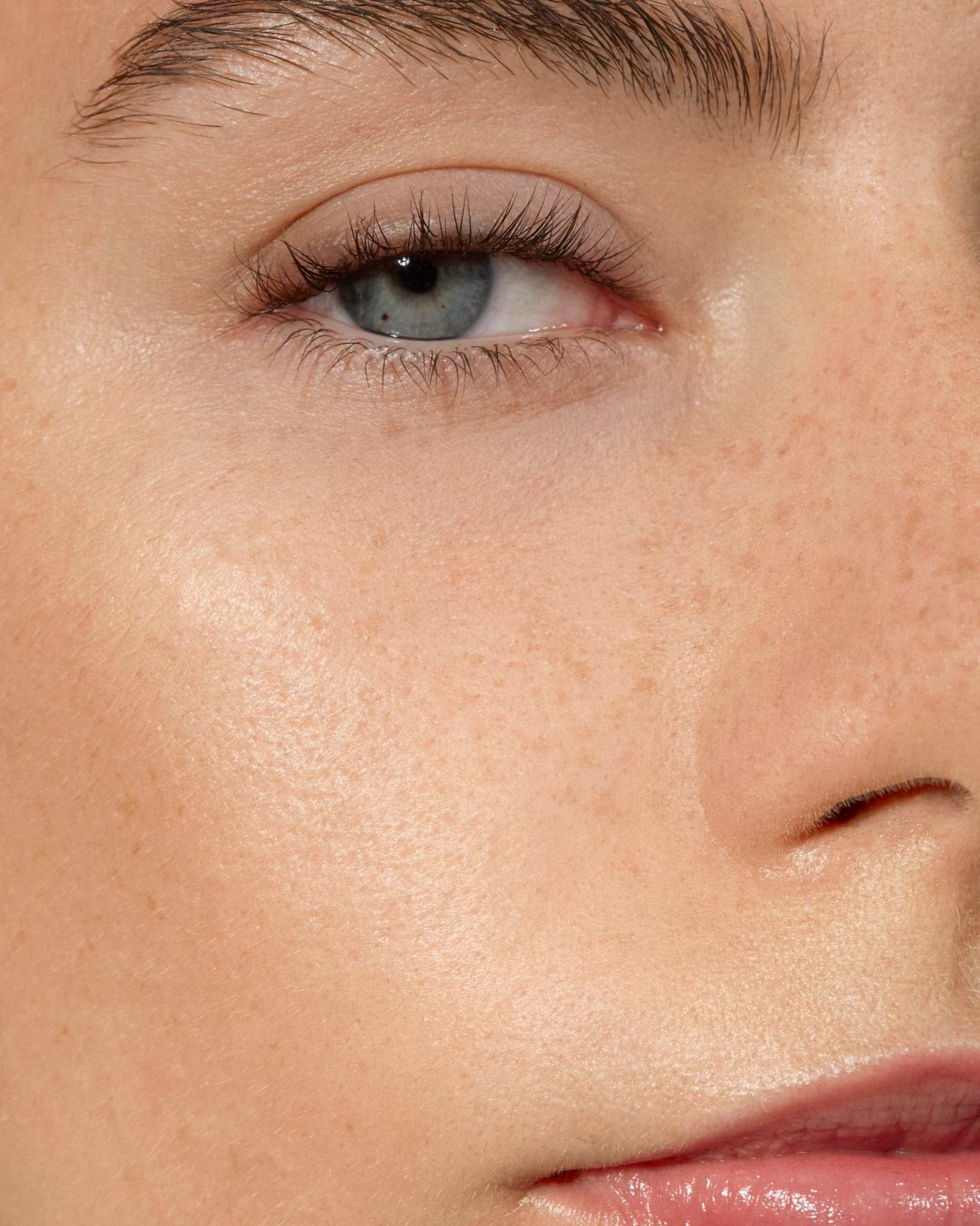 Model wearing MÁDARA Organic Skincare sun flower serum on A3513 serum on skin; close-up portrait shows natural application results.