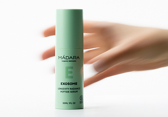 MÁDARA Exosome Longevity Radiance Peptide Serum bottle with blurred hand movement in the background