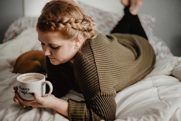 Girl drinking coffee in bed