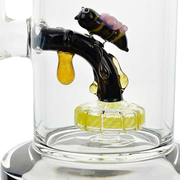 Close up shot of clear glass bong perc honeybee with big eyes on tree branch with dripping honey design