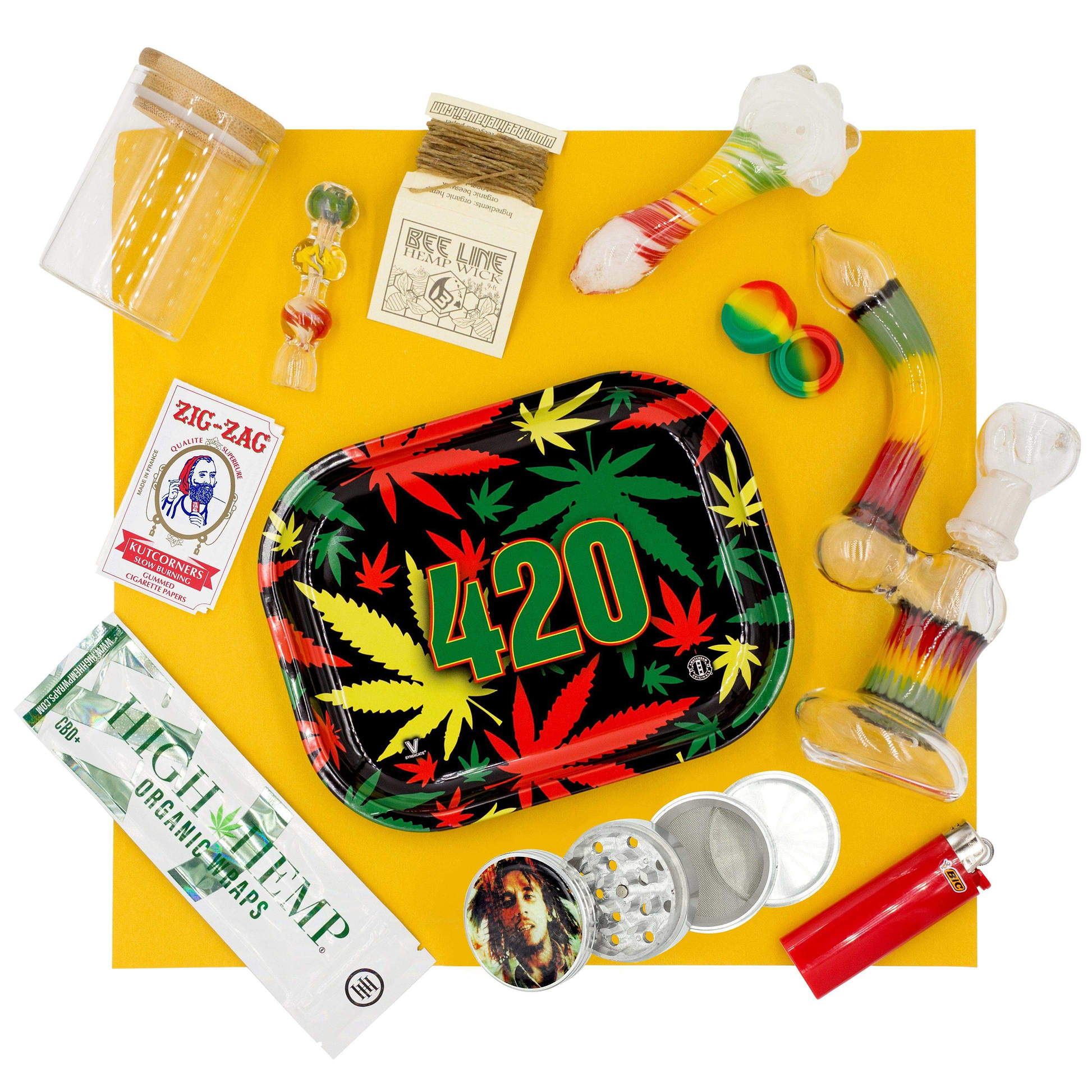 Set of rasta bong, herb bowl, 4-inch pipe, chillum, 420 tray, grinder, jar, container, wraps, zigzag pack and Bic lighter