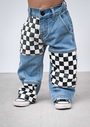 Little Trouble Checkered Patch Baggy Jeans - Blue jeans with checkered patches worn by a kid on a plain background