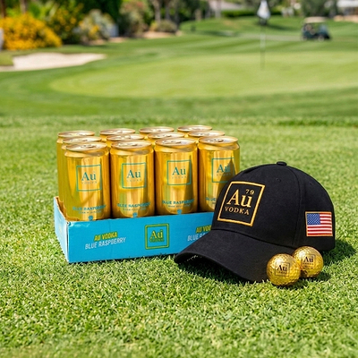 Au Vodka cans on a golf course with a cap and golf balls.