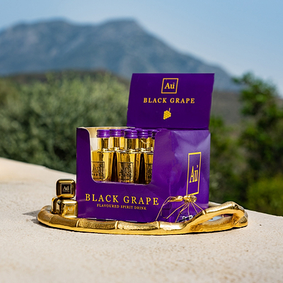 A Multipack of Au Vodka Black Grape miniatures, displayed in front of a scenic background.