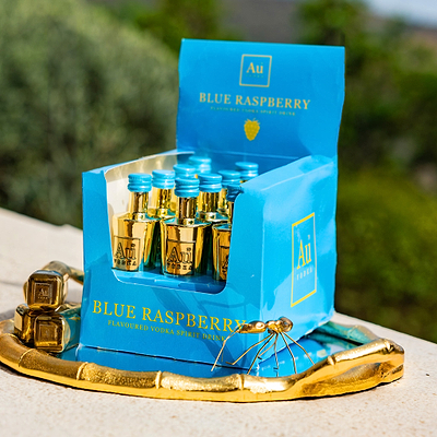 Au Vodka Multi Pack of 12 Blue Raspberry 50ml Miniature Bottles, in an outdoor scenic background.