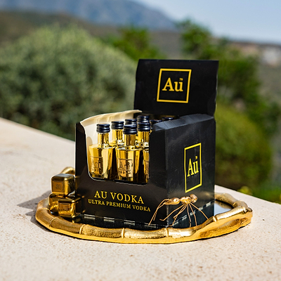 Au Vodka Original Miniature 50ml, packaged in 12 mini bottles. Against an outdoor summer background.