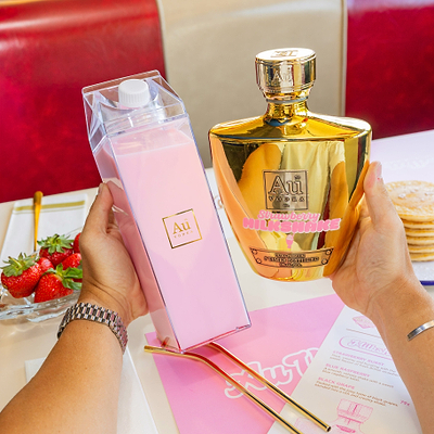 Au Vodka Strawberry Milkshake, Cocktail Carton filled with Vodka Milkshake, on  a Diners Table with dessert items