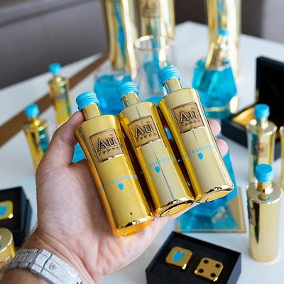 Person holding 3 Au Vodka Miniature 50ml Bottles.