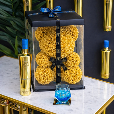 Gift box with a Gold Rose Teddy Bear, Gold Vodka Bottle, with a glass of blue liquid. Au Vodka branding.