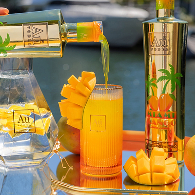 Au Vodka USA Mango Passion being poured into a glass with mango garnish