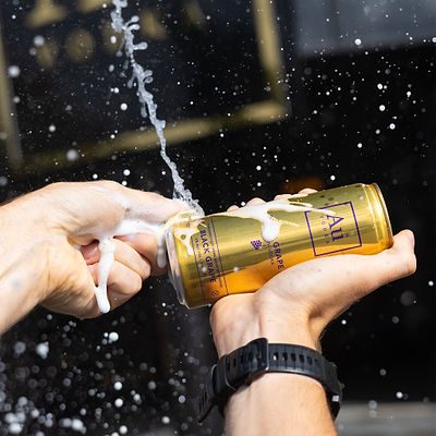 Person holding a gold can breaking it with the can key