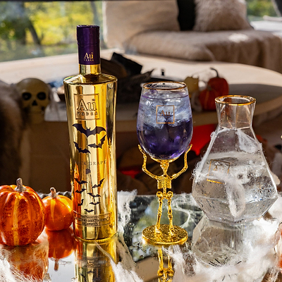 Halloween-themed bottle and glass with decorative elements on a table.
