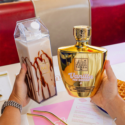 Gold bottle of Vanilla Ice Cream with a carton of vanilla ice cream on a table.