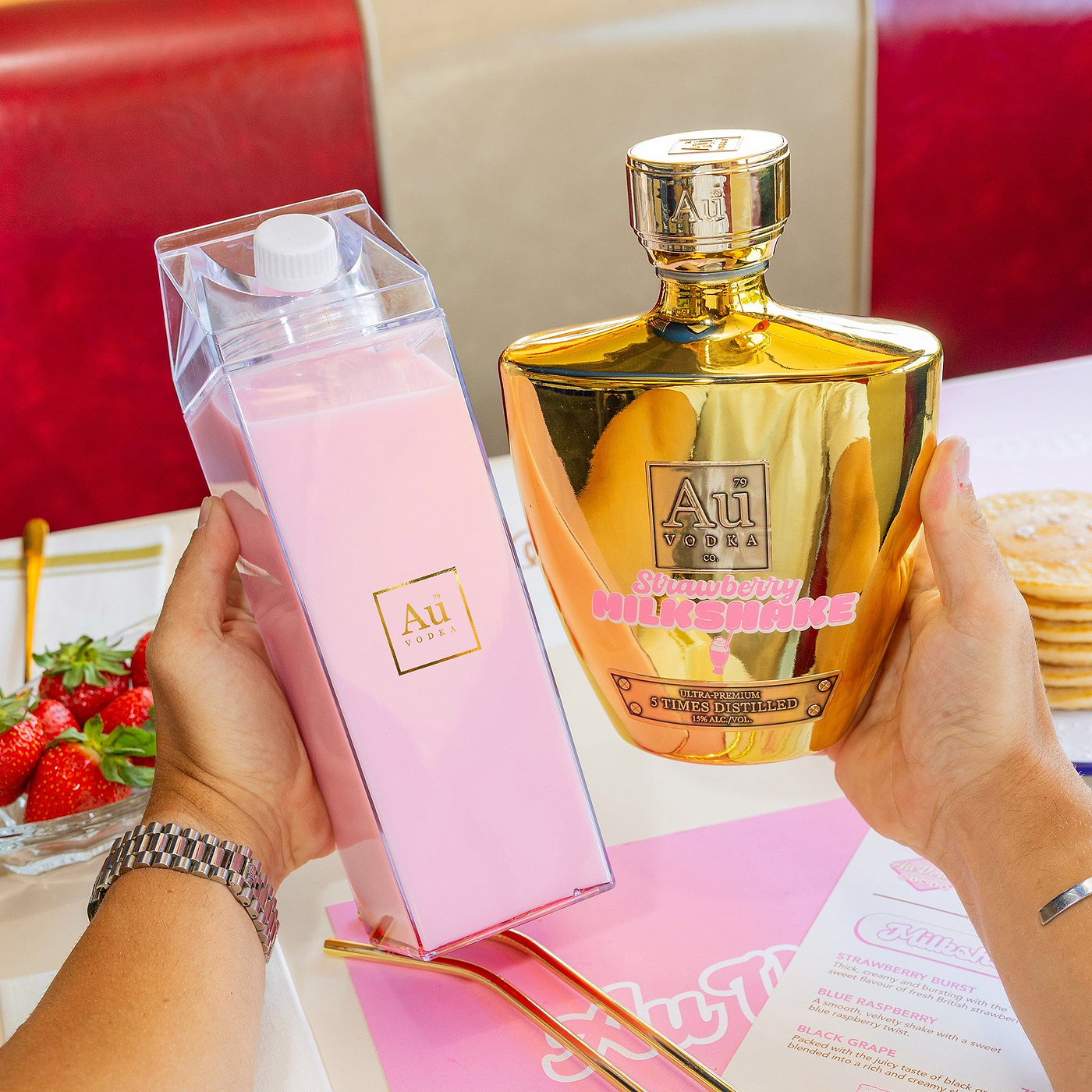 Gold strawberry milkshake and cocktail carton in diner setting