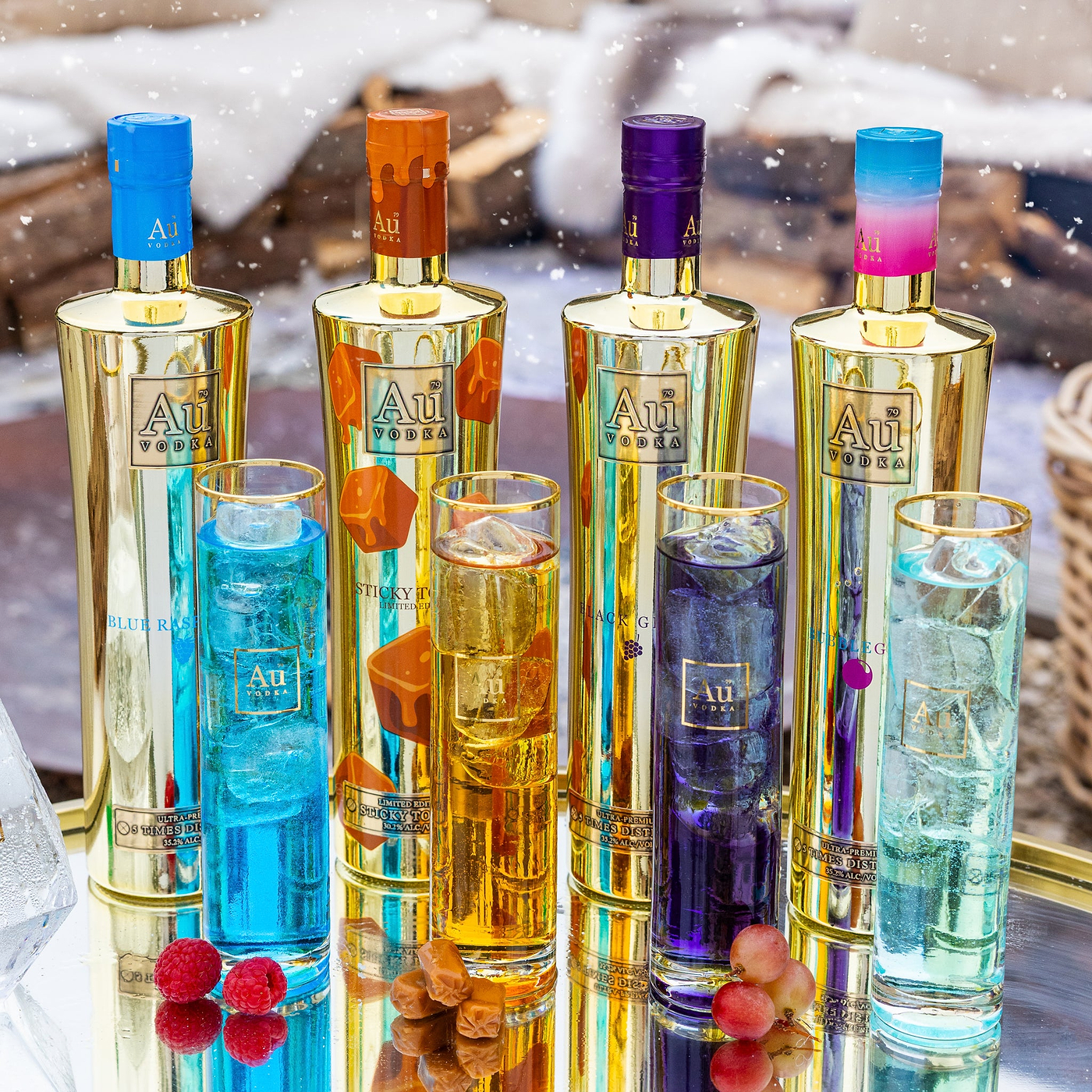 Set of colorful bottles with 'Au' branding on a reflective surface.