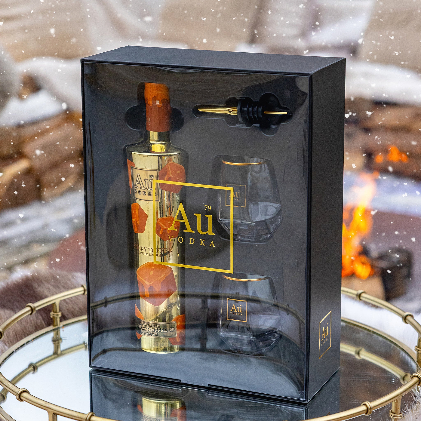 Au Vodka bottle and glasses set in a decorative box with a snowy background