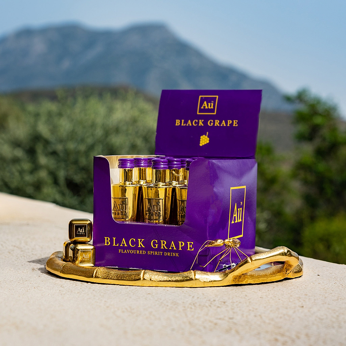 A Multipack of Au Vodka Black Grape miniatures, displayed in front of a scenic background.