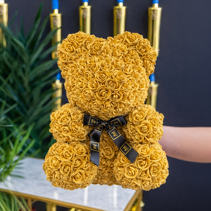 Holding a Bear made up of Gold Roses, with Au Vodka Branding.